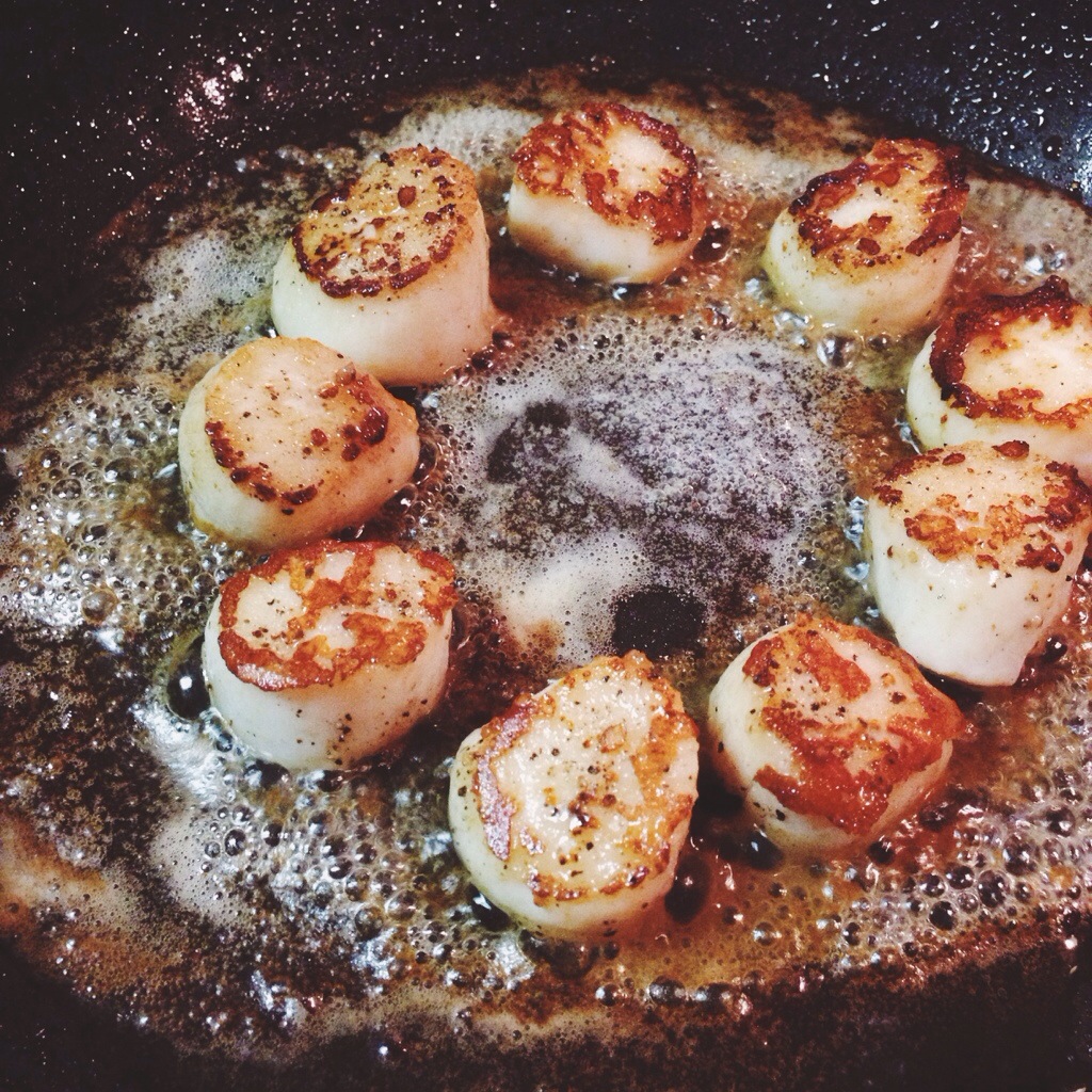 Scallops cooking in butter.